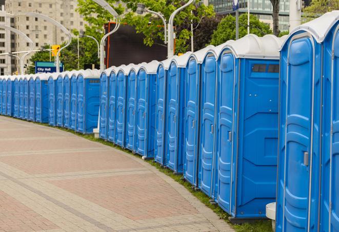 a row of portable restrooms at an outdoor special event, ready for use in Riley, MI